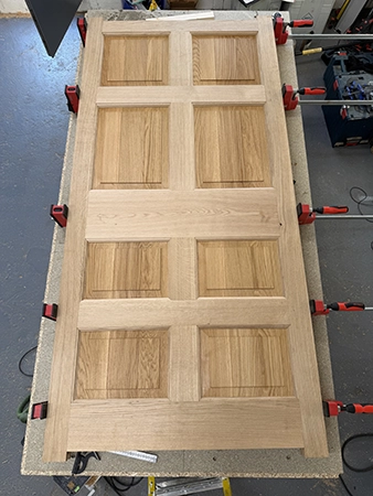Door assembled with panels